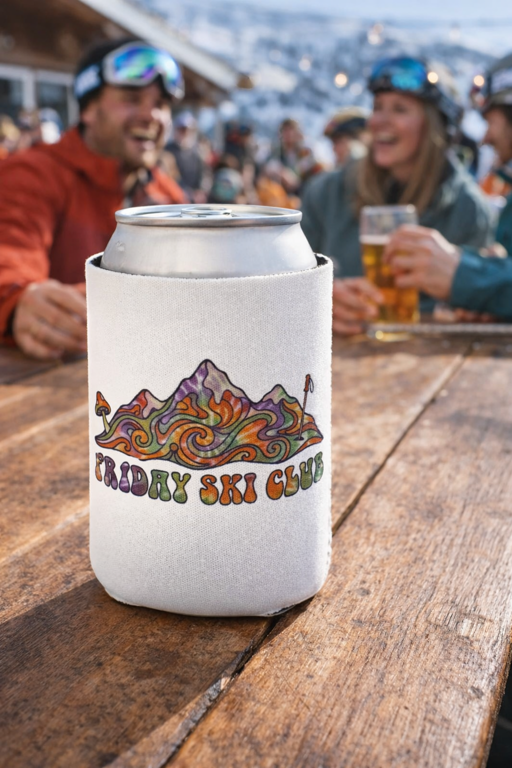 Can cooler with 'Friday Ski Club' design on a wooden table with people in the background